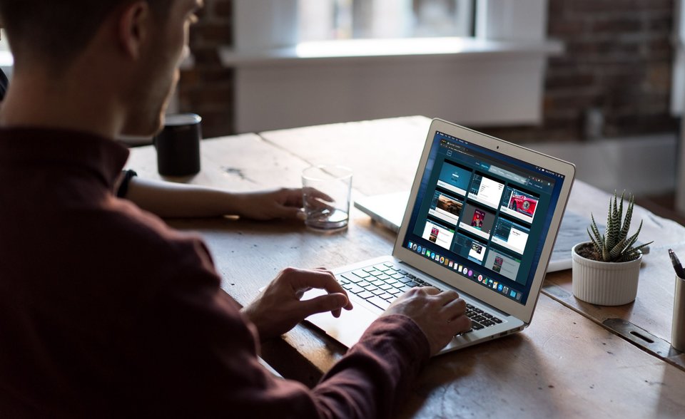 A man viewing videos on a laptop